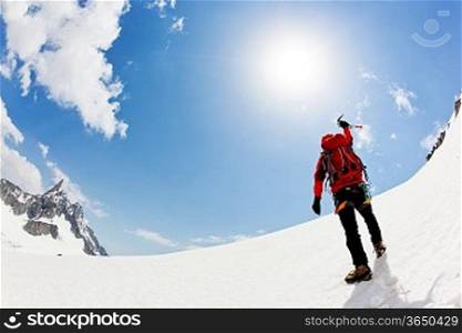 A male mountaineer expresses his joy reaching the summit of a snowed mountain peak. Mont Blanc, France.