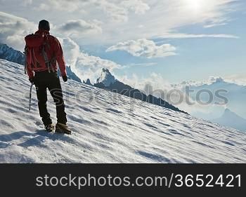 A male mountaineer walking uphill on a glacier. Mont Blanc, France.