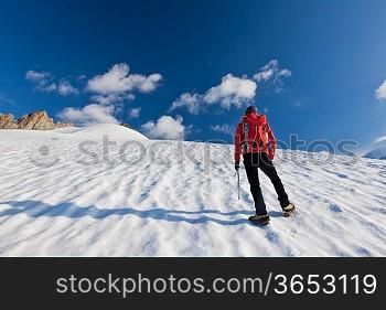 A male mountaineer walking uphill on a glacier. Mont Blanc, France.