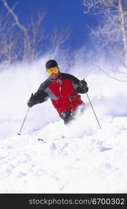 A male skier skiing down a slope