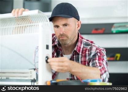 a male technician installing radiator