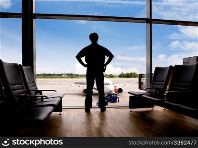 A male waits in a terminal at an airport