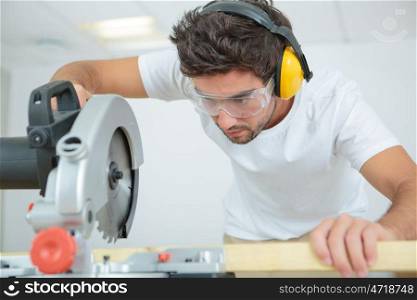a male worker using circular saw
