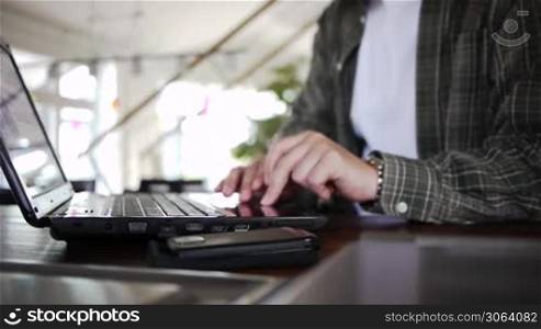 a male works on a notebook on a desk or table, ein Mann arbeitet an seinem Notebook auf einem Tisch