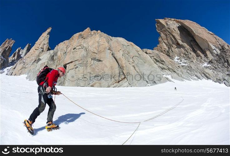 A male young climber walks along a glacier in the south face of Mont Blanc massif. Petit Capucin, Mont Blanc, France.