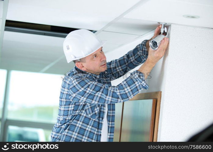 a man adjusting a cctv