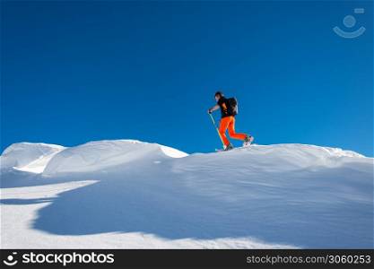A man alpine skier climb on skis and sealskins In alpine ridge of alps