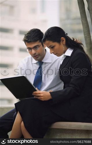 A man and a woman working on a laptop
