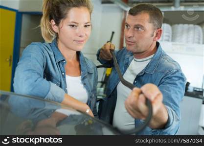 a man and woman changing windshield