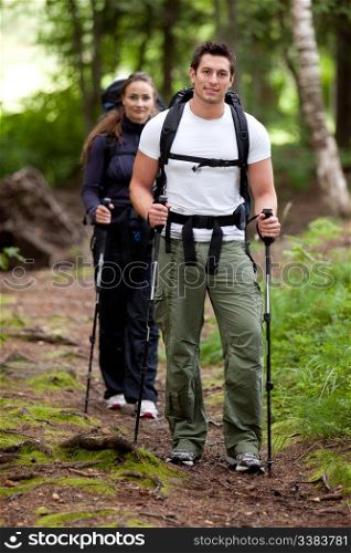 A man and woman on a camping trip in the forest.