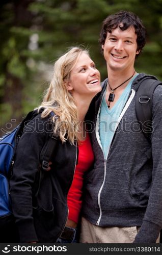 A man and woman outdoors on a hike in a forest