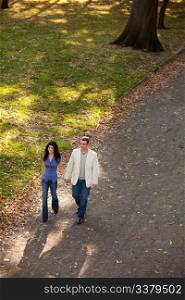 A man and woman walking in a park on a sunny day