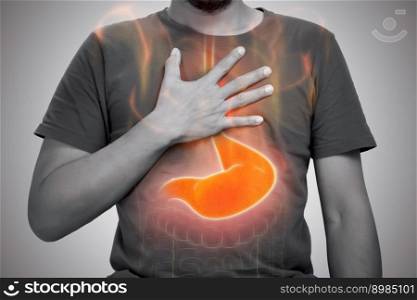 A man burning sensation in chest from acid reflux on gray background.