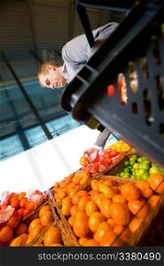 A man buying fresh fruit at a grocery store