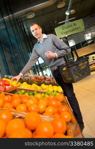 A man buying fresh fruits and vegetables at a grocery store