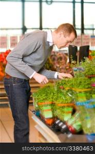 A man buying fresh herbs at a grocery store
