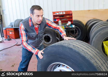 a man carrying tires outdoors