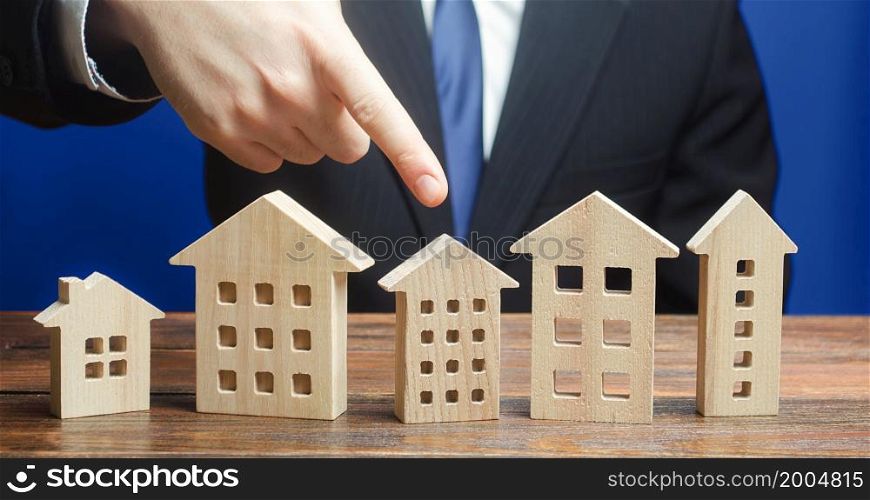 A man chooses an apartment house among many propositions options in the real estate market. Realtor services to find suitable options. Housing solution. Facilities and infrastructure. Investments.