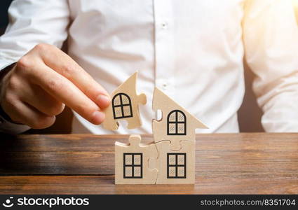 A man collects a house of puzzles. Construction of your own residential building. Mortgage loan, residential expansion and improvement of living conditions. Creating a family. The concept of stability