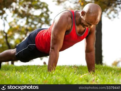 A man doing a push up in a park