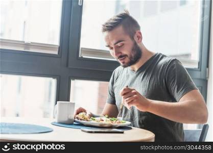 A man eating a healthy morning meal, breakfast at home. Fit lifestyle.. Man eating a healthy breakfast.