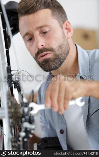 a man fixing bike indoors