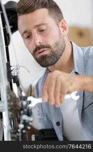 a man fixing bike indoors