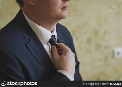 A man flicks a knotted tie.. The process of putting on the attire of men at a business meeting 8887.