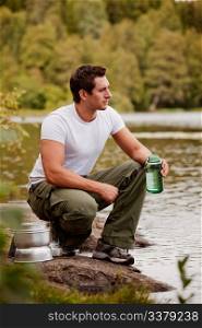 A man getting water on a camping trip in the forest