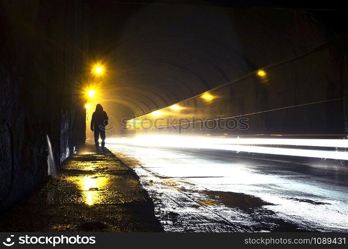 A man going through the dark tunnel