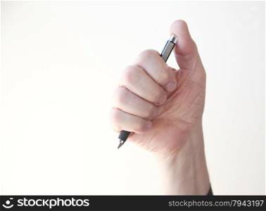 A man grasps a ballpoint pen in his hand.