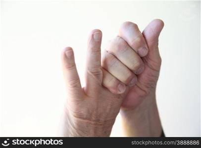 A man grasps the first two fingers of his left hand.