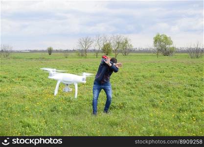 A man hides himself from a collision with a drone. Quadrocopter flies to the person.. A man hides himself from a collision with a drone. Quadrocopter flies to the person