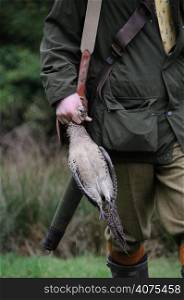A man holding a dead bird