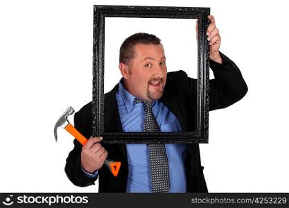 a man holding a wooden frame and a hammer