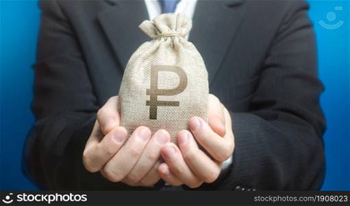 A man holds out a russian ruble money bag. Budget management, tax collection. Provision cash financial loan credit. Trade, economics. Granting financing business project or education. Bank deposit.