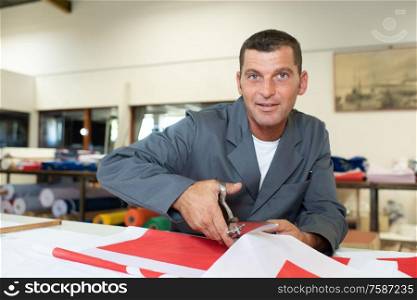 a man is cutting coloured sheets