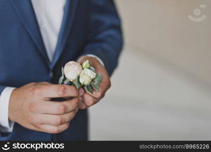 A man is holding a boutonniere.. Boutonniere in the hands of the groom 2456.