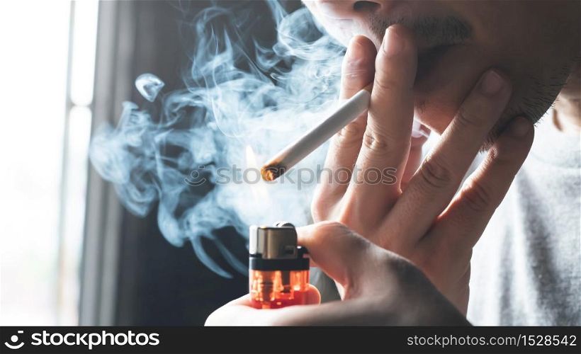 A man is smoking a cigarette at home