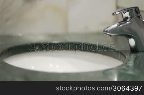 A man is washing his hands, view from side, ein Mann wascht sich die Hande