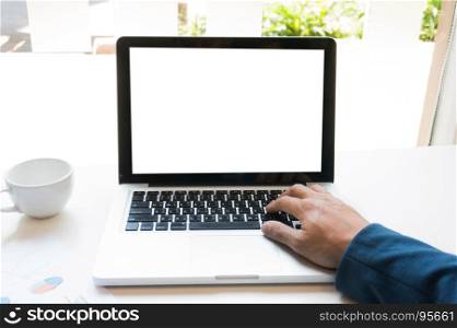 A man is working by using a laptop computer on wooden table. Hands typing on a keyboard.