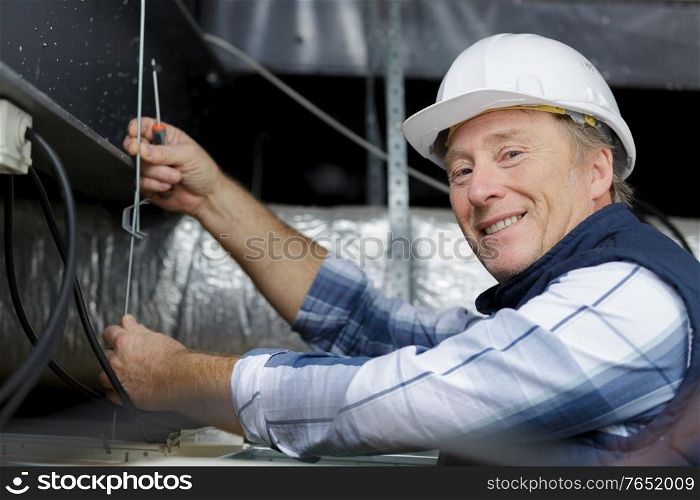 a man is working on a ceiling