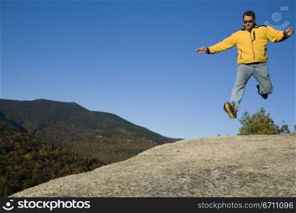 A man jumping on a rock