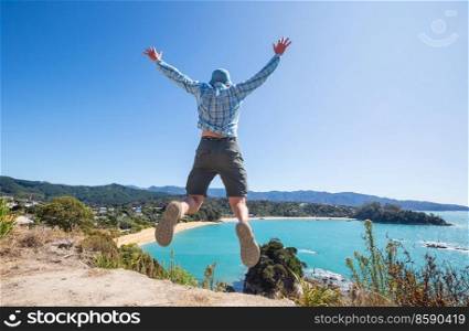 a man jumps above beautiful New Zealand coast 