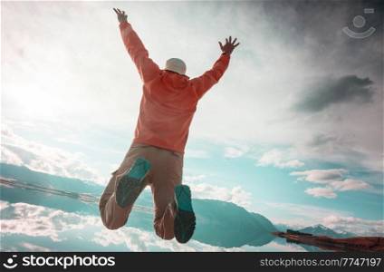 a man jumps off a cliff into a mountain lake