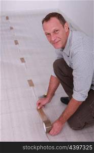 A man laying a new floor.
