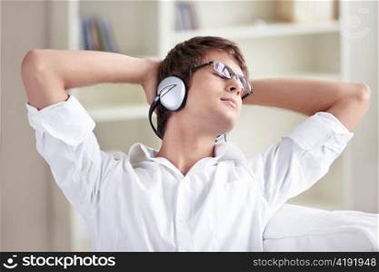 A man listens to music on headphones at home