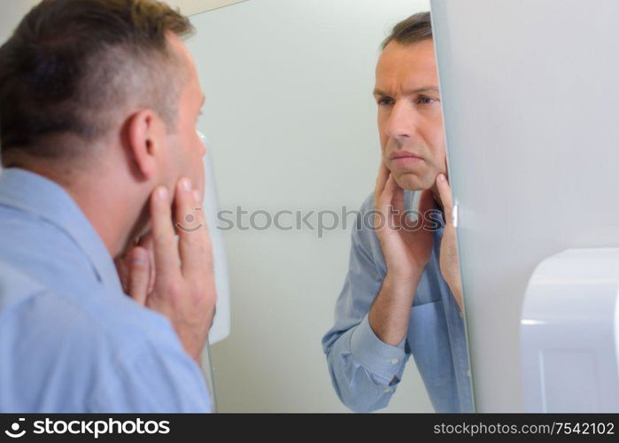 a man looking in mirror