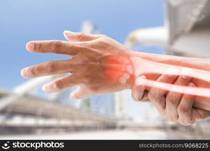 A man massaging painful wrist on a gray background. Pain concept. Osteoporosis