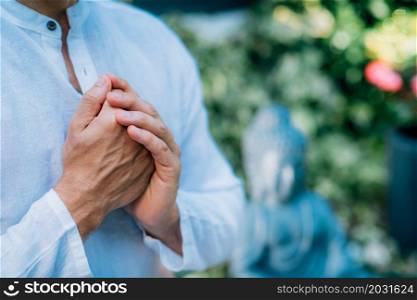 A man meditates outdoors and keeps hands together in a prayer position. . Man meditating Outdoors and keeping hands together in a prayer position.